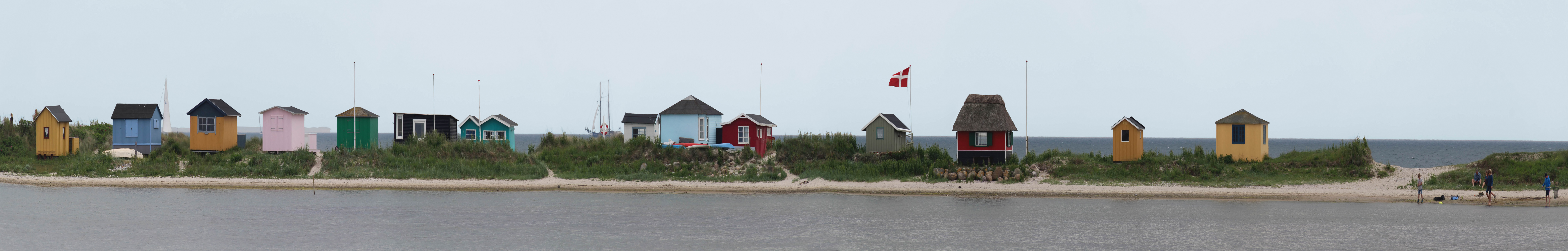 Strasse mit bunten Bootshäuschen an Strand in Dänemark