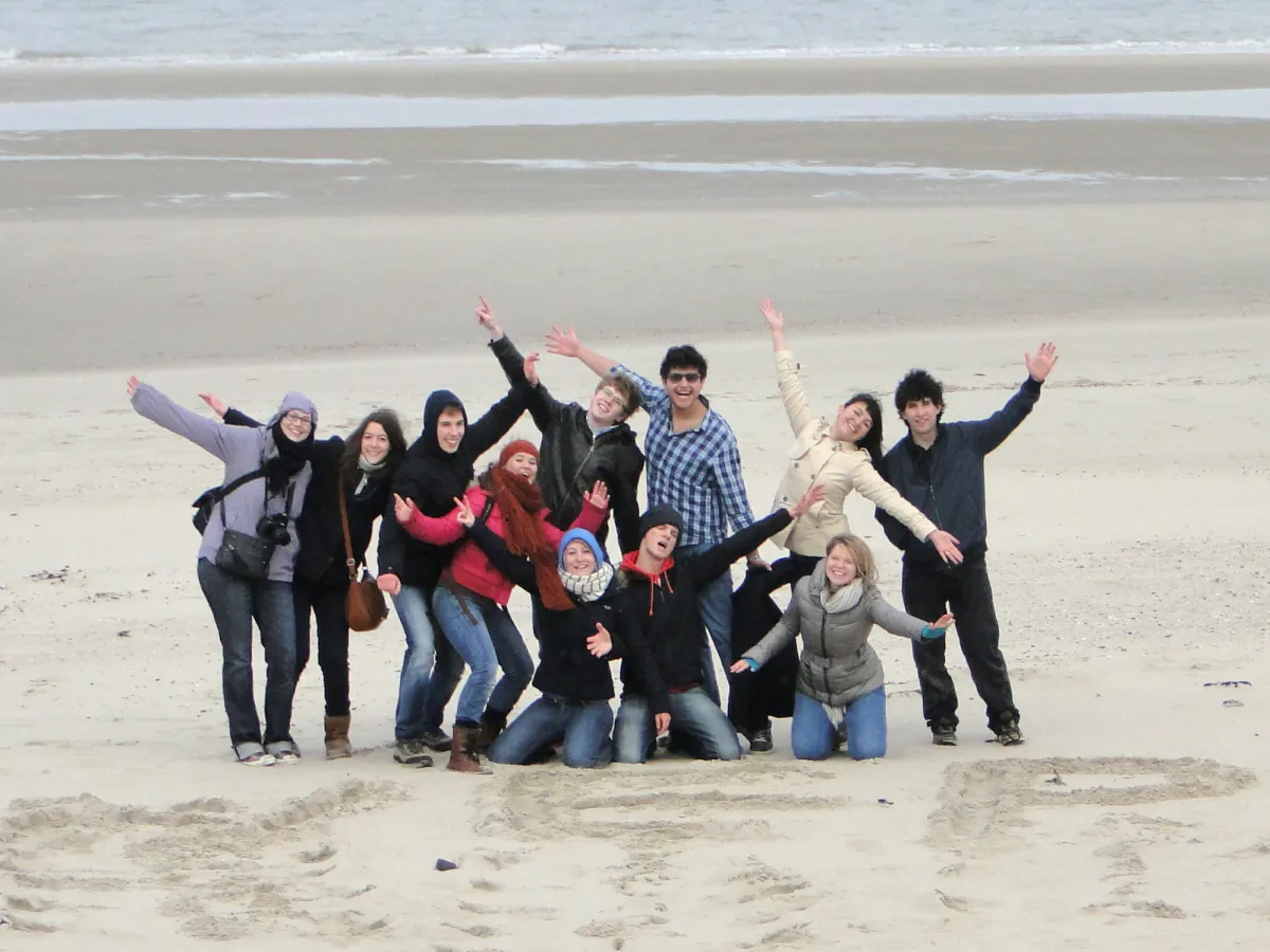 Fröhliches Gruppenbild von Austauschschüler am Strand in Belgien