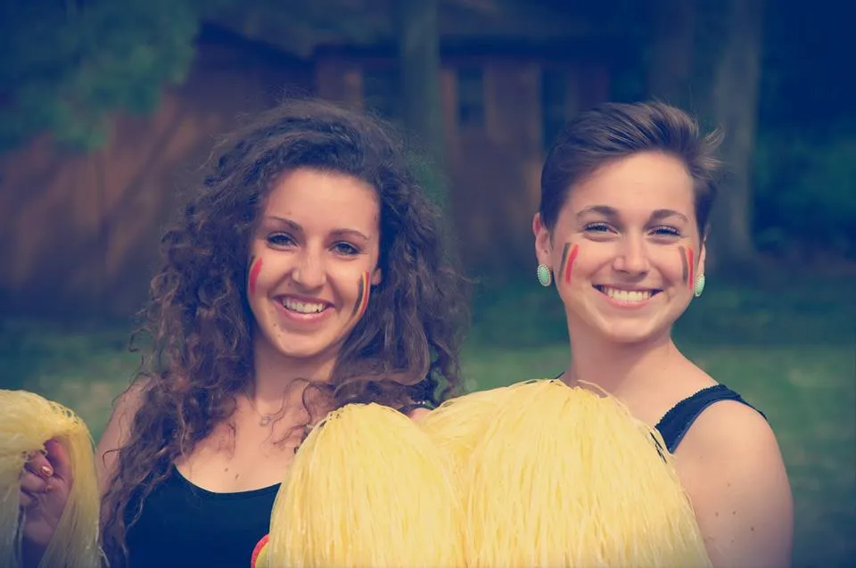 Zwei belgische Cheerleaders mit Pompoms lachend