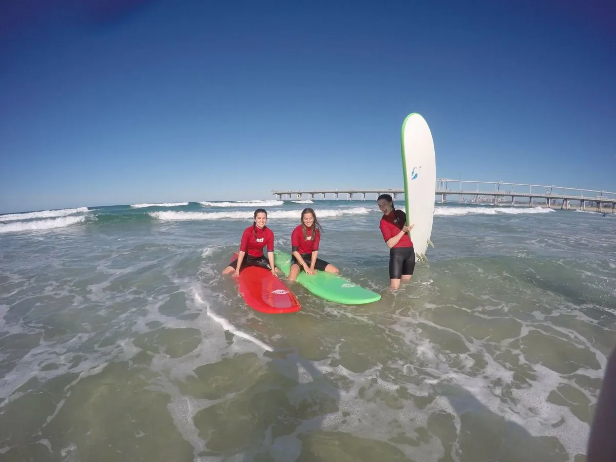 Junge Surfer mit Longboards im Whitewash am Strand von Australien