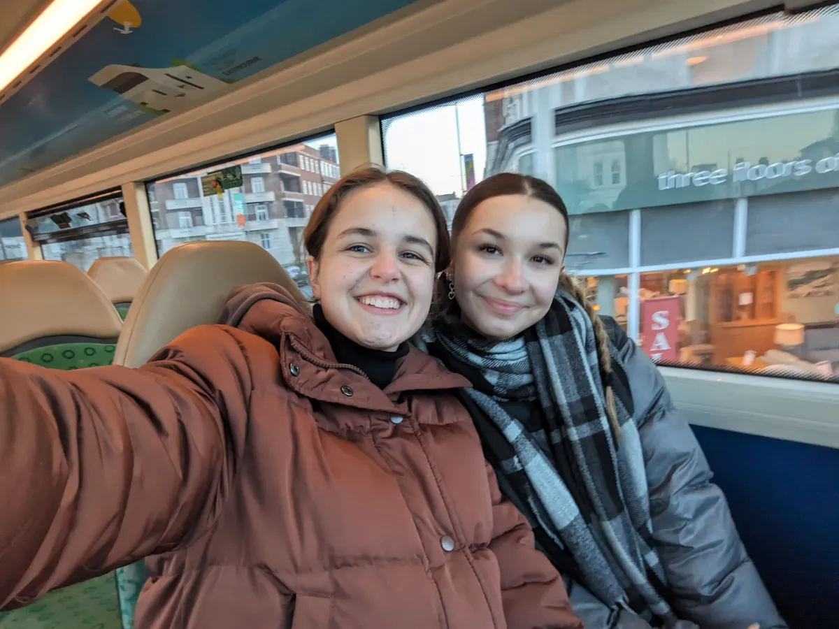 Selfie von zwei Maedchen im Doppeldeckerbus in Winterjacken 