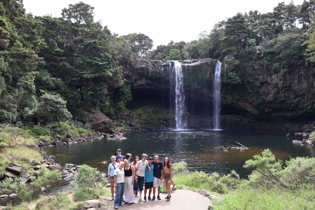 Wasserfall in Dschungel Gruppe Schüler posieren davor