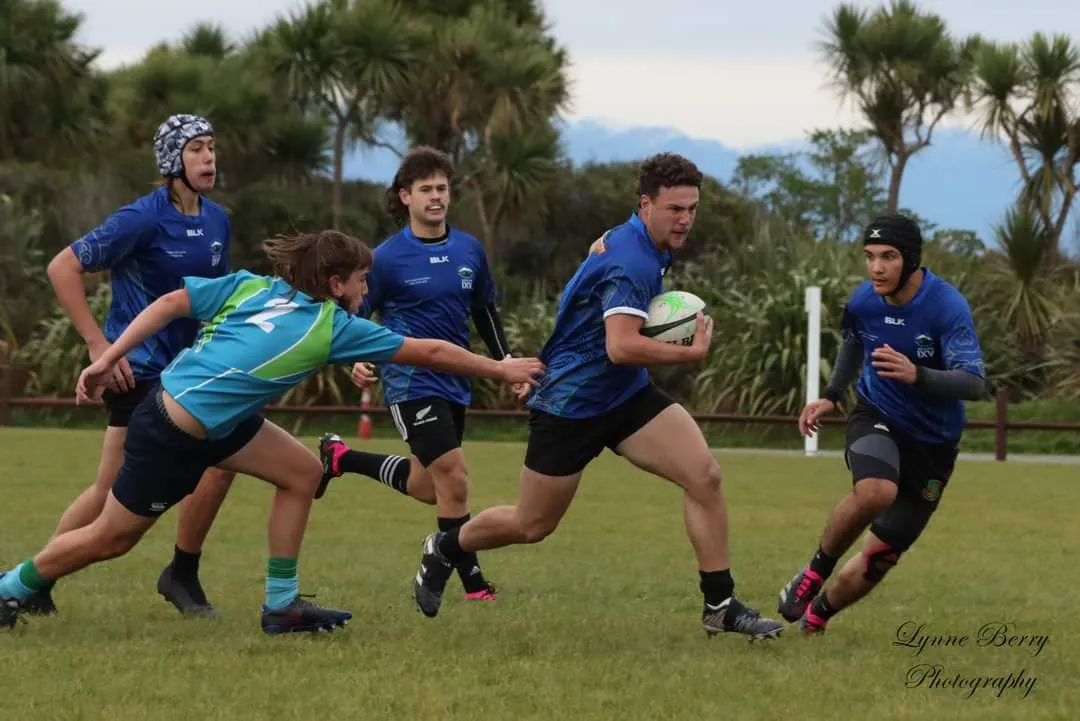 Rugbyteam in blauem Tenue auf Rasen am laufen