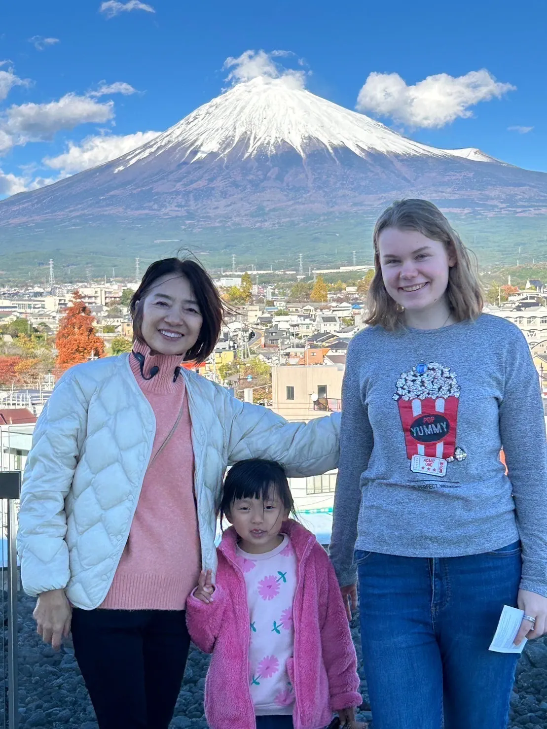 Austauschschülerin mit Gastfamilie haltend vor Mt. Fuji lachend
