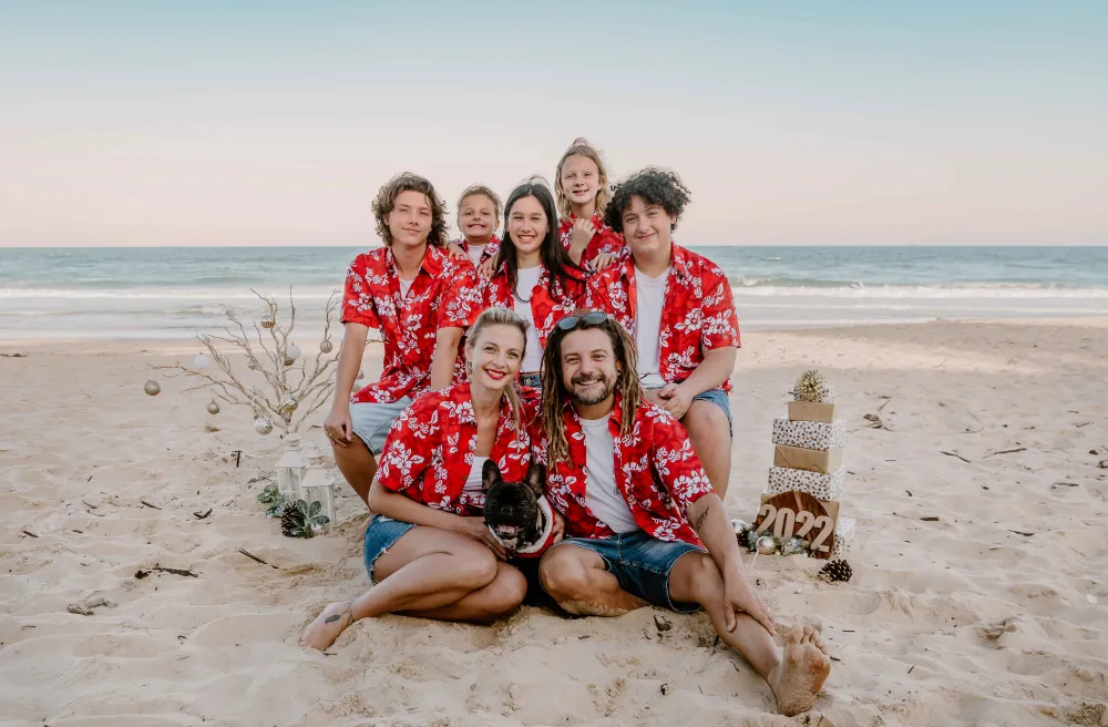 Gruppenbild mit Gastfamilie in Sommeroutfit am weissen Sandstrand