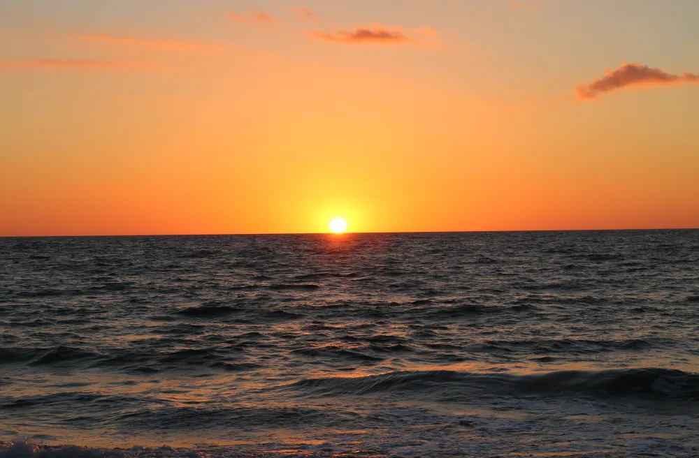 Knalloranger Sonnenuntergang über dunklem Atlantik
