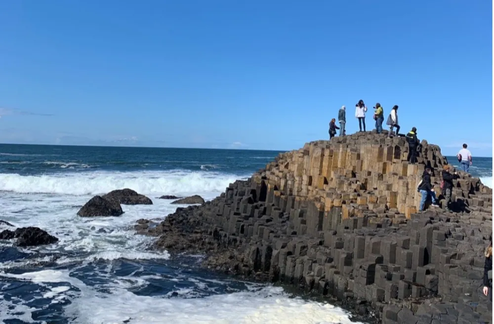 Blick auf Meer mit Steinformationen auf der Schüler stehen weisse Wellen