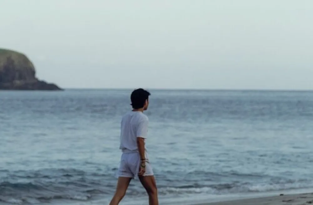 Junge mit Fussball am Meer