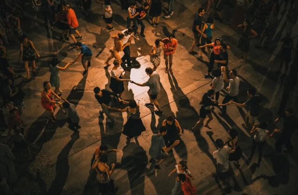 Gruppe von Menschen tanzt am Abend draussen auf der Strasse