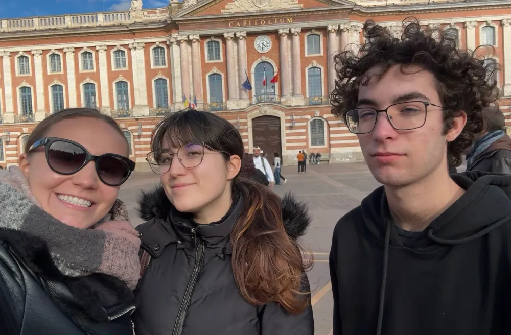 Selfie von drei Jugendlichen vor dem Capitole in Toulouse, bei sonnigem Wetter