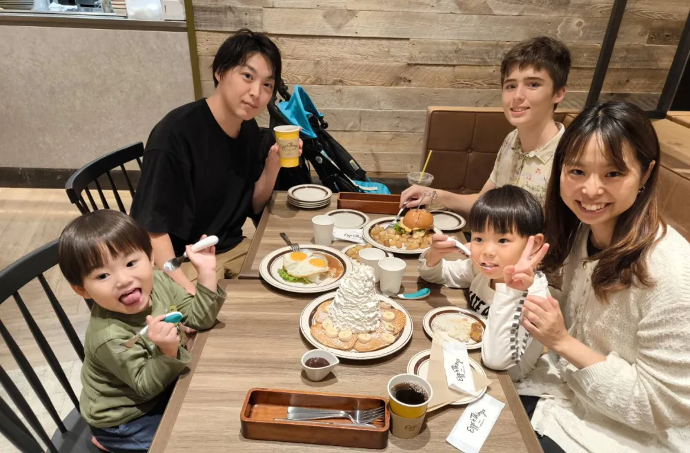 Austauschschülerin isst mit japanischer Gastfamilie am Tisch