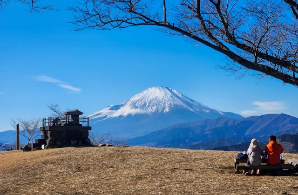 Menschen auf Bank geniessen Ausblick auf Vulkan auf Hügel in Japan