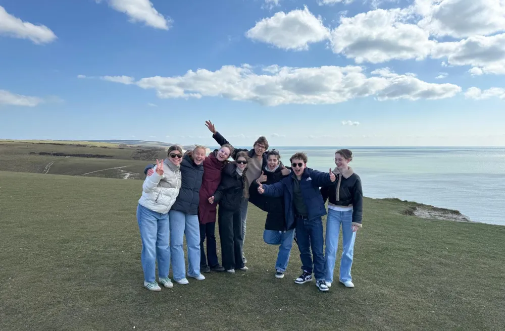 Gruppe auf der Klippe mit Daumen hoch