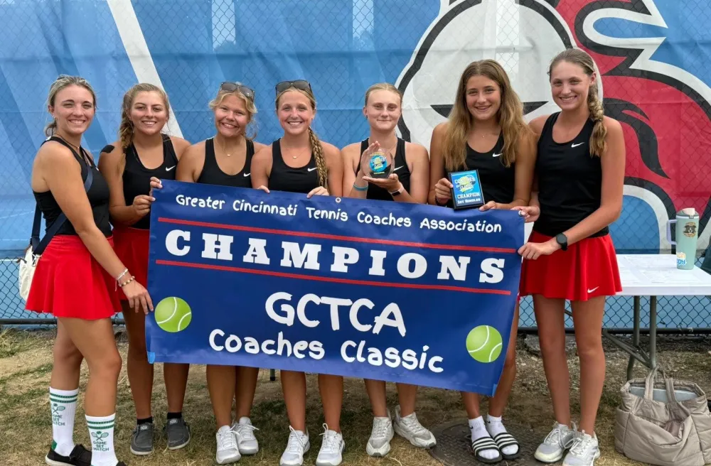 Jara mit ihrem Tennisteam nach einem Turniergewinn – sie halten Banner und Pokale.