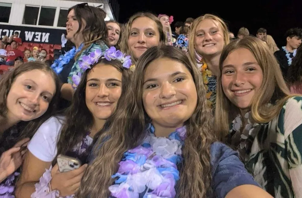 Jara mit anderen Schülerinnen im Stadion – alle tragen Hawaii-Deko.