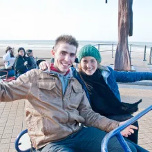 Zwei junge Menschen auf Dune-Buggy am Sand