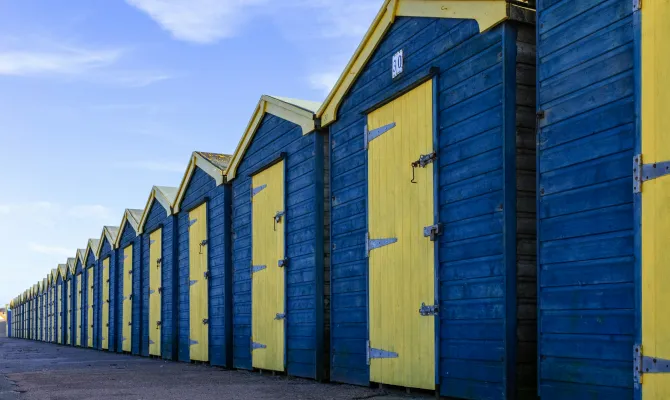 Blau-gelbe Badehütten am Strand von England