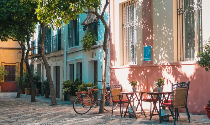 Tische und Stühle eines Cafés in spanischer Altstadt an einem Sommertag