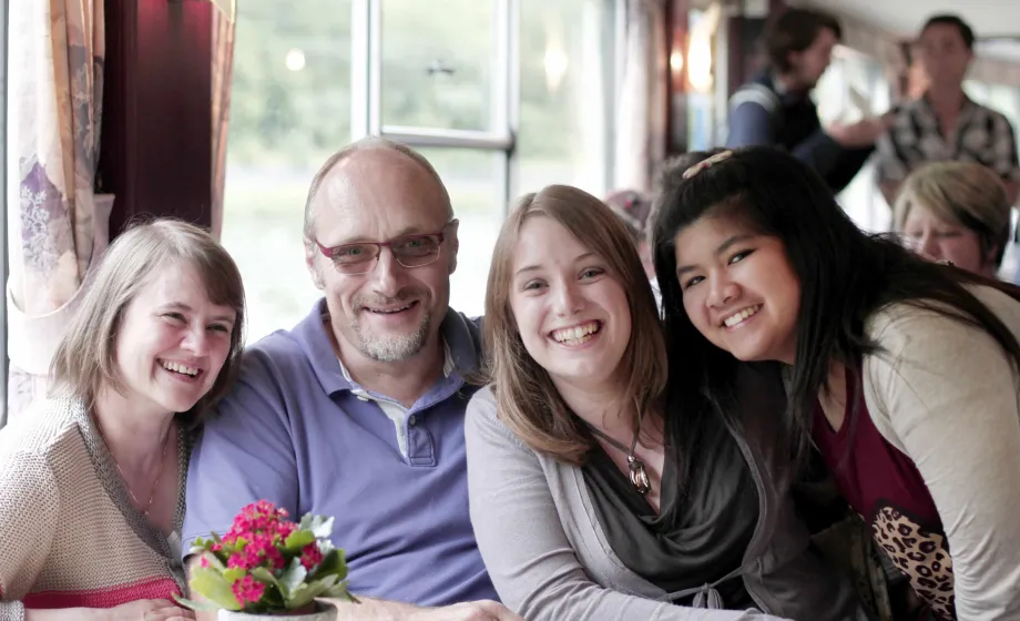 Belgische Gastfamilie mit zwei Austauschschülerinnen im Restaurant
