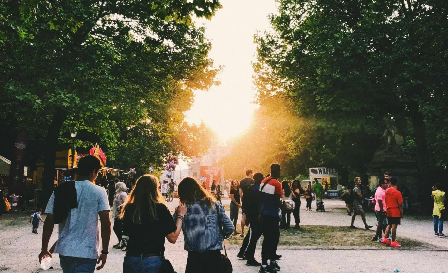 Schüler laufen durch Park bei Sonnenuntergang im Sommer