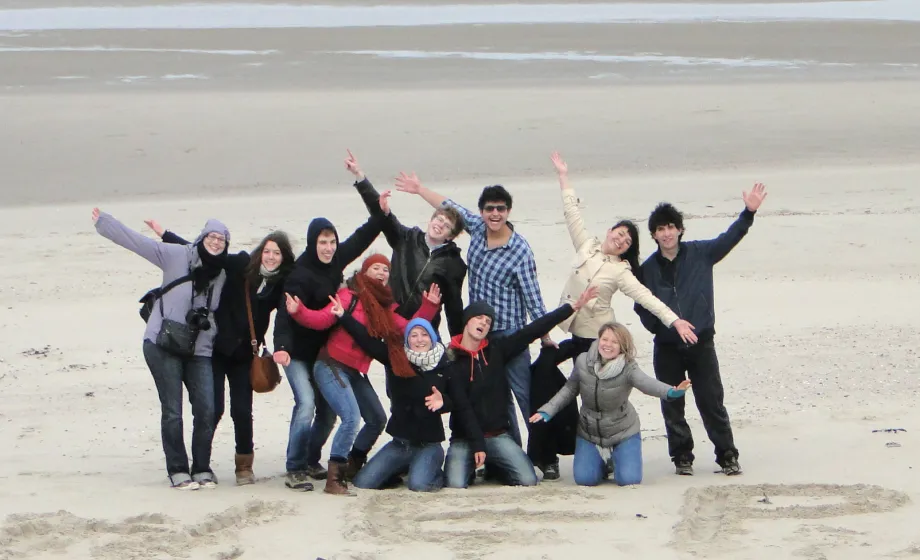 Fröhliches Gruppenbild von Austauschschüler am Strand in Belgien