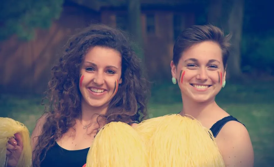 Zwei belgische Cheerleaders mit Pompoms lachend