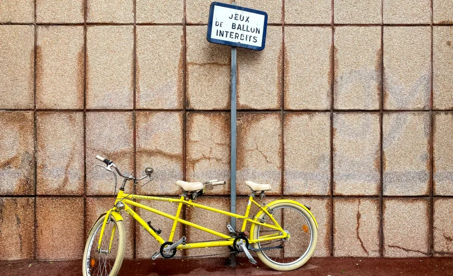 Gelbes Tandemfahrrad steht an Wand in Frankreich
