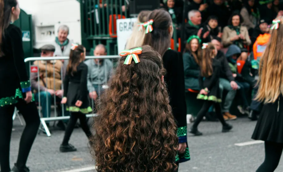 Mädchen an St. Patrick's Day Parade mit irischer Schleife im Haar