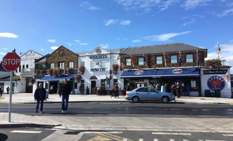 Altstadt in Irland mit Strasse und Autos und Häuser bei blauem Himmel