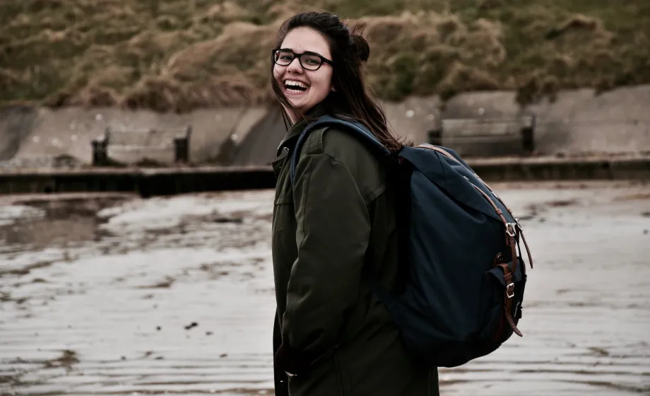 Lachende Schülerin am Strand im Herbst in Irland