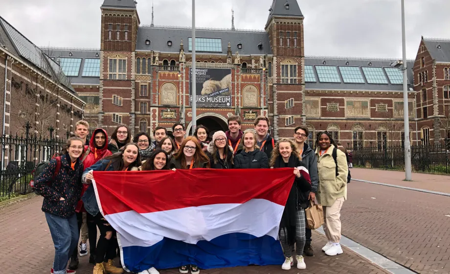 Gruppenbild Austauschschüler vor dem Bahnhof Amsterdam mit niederländischer Flagge