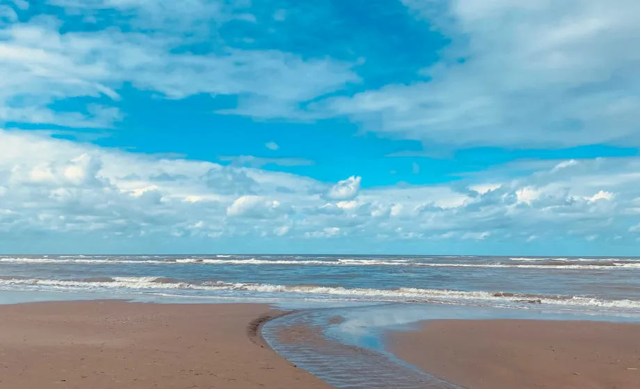 Strand an der Nordsee mit blauem Himmel und weissen Wolken