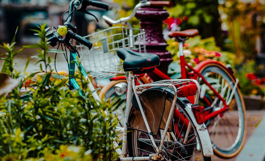 Zwei bunte Fahrräder stehen an Strassenrand zwischen Blumenkasten