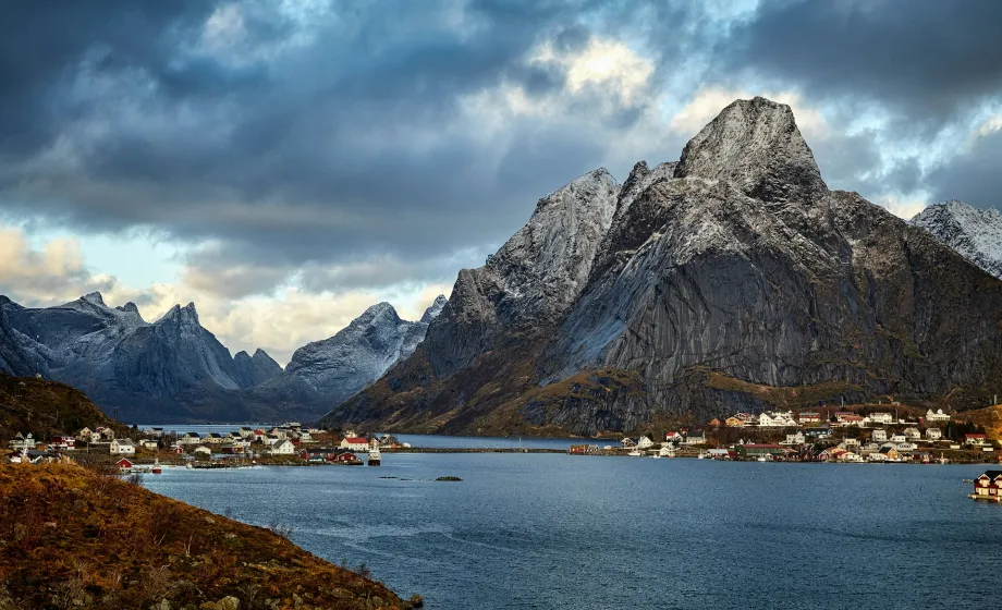 Norwegischer Fjord, Küstendörfer, Meer, Berge, dunkle Wolken, heller Himmel