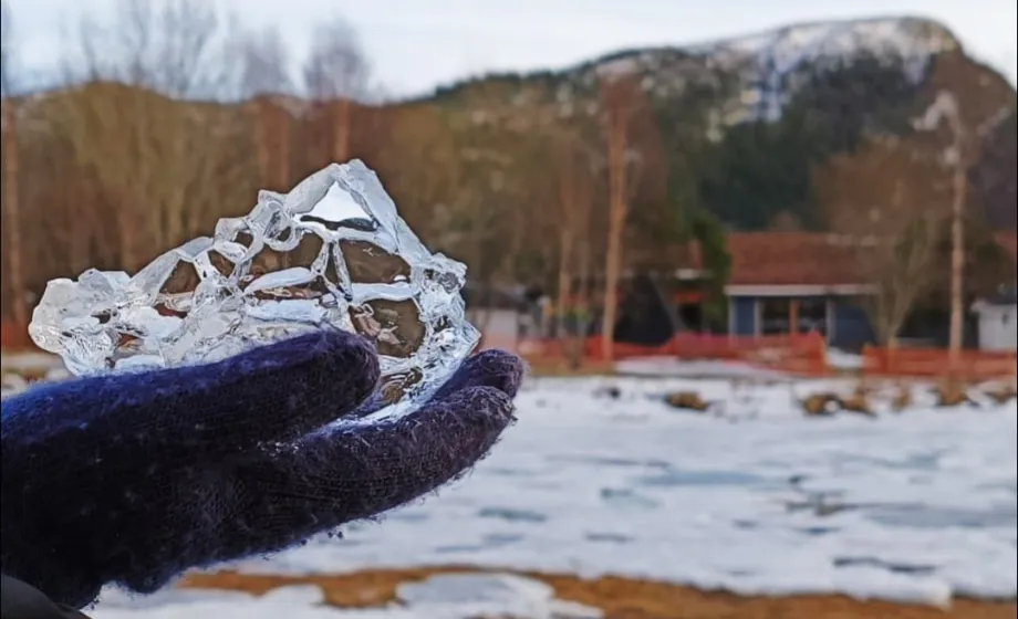 Eis in Form eines Berges auf Hand gehalten mit Handschuh