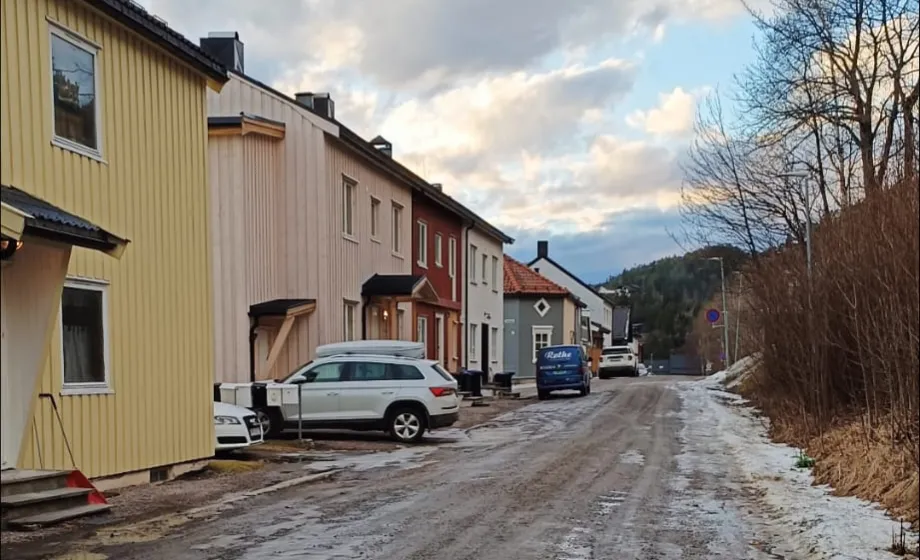 Strasse durch ländliches norwegisches Viertel im Frühling mit gelbem Haus