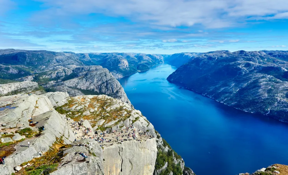 Blick über blau-leuchtender Fjord und schroffe Berggestein
