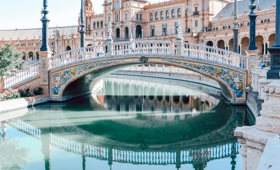Schmucke alte Bogenbrücke über Kanal mit Laternen auf der Seite in Spanien