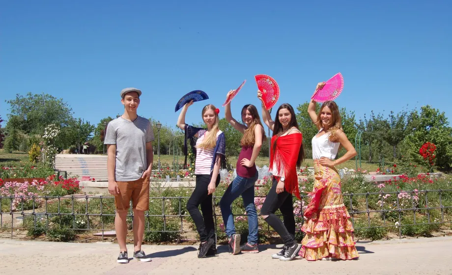 Austauschschüler in Spanien posieren mit Flamencokleider und Fächern