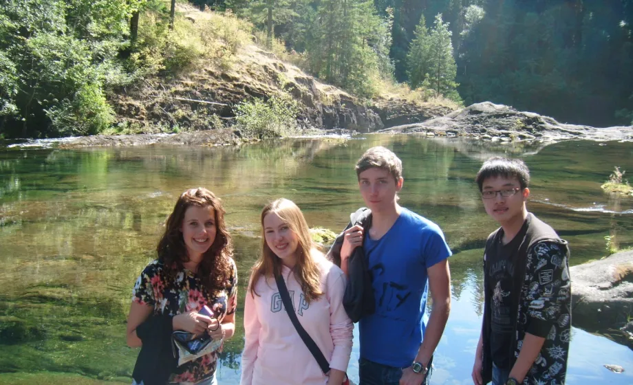 Wandernde Schüler vor grünem See lächelnd