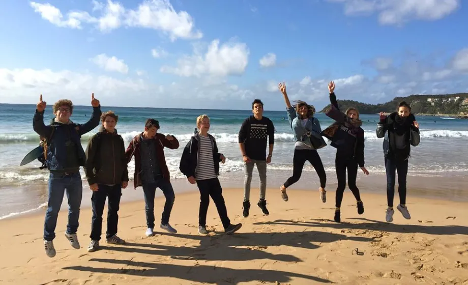 Lunge Menschen springen in die Luft auf Sand am Strand in Australien