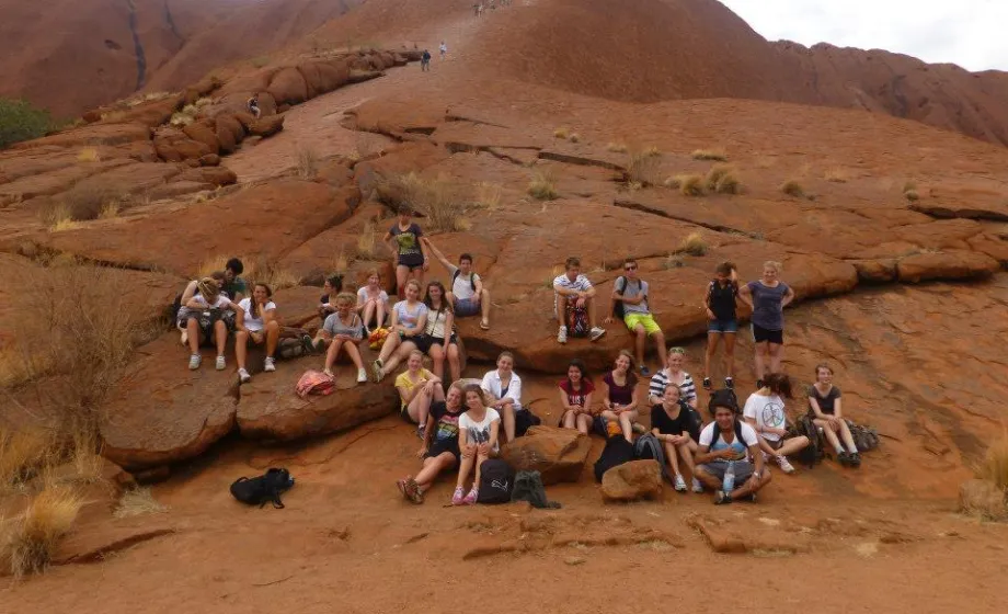 Gruppe junge Wanderer auf rotem Urulu in Australien