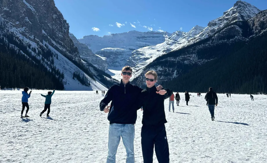 Zwei Junge auf schneebedecktem See mit blauem Himmel in Sonne