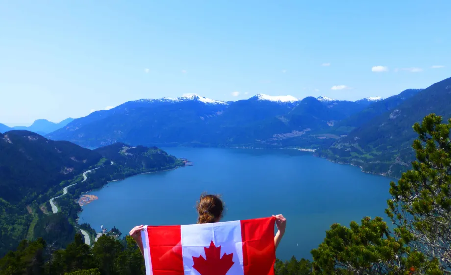 Mädchen steht mit kanadischer Flagge richtig blauer See