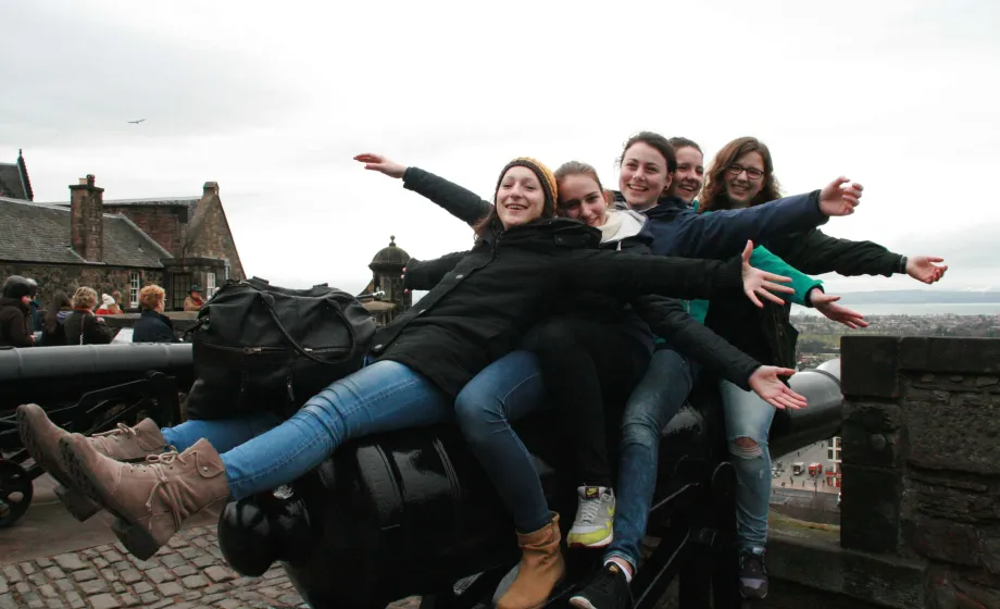 Gruppe Mädchen sitzt auf Kanone in einer Bucht in England