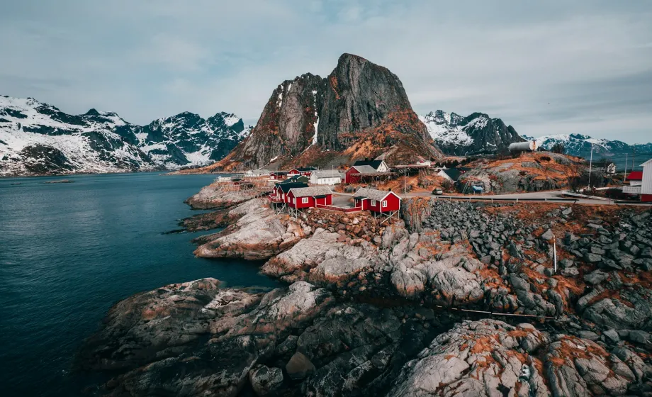 Küstendorf in Norwegen umgeben vom Meer und von steilen Bergen und Felswänden