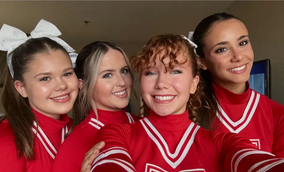 Cheerleader Mädchen in rotem Gewand lachend