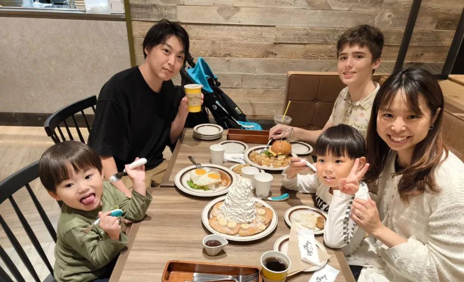 Austauschschülerin isst mit japanischer Gastfamilie am Tisch