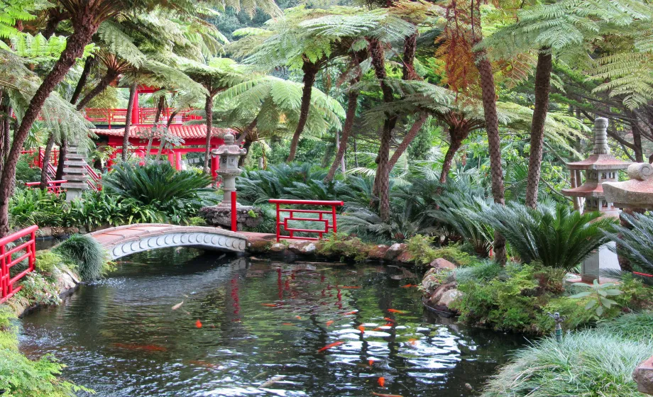 Botanischer Zengarten mit roter Brücke über Teich in Japan