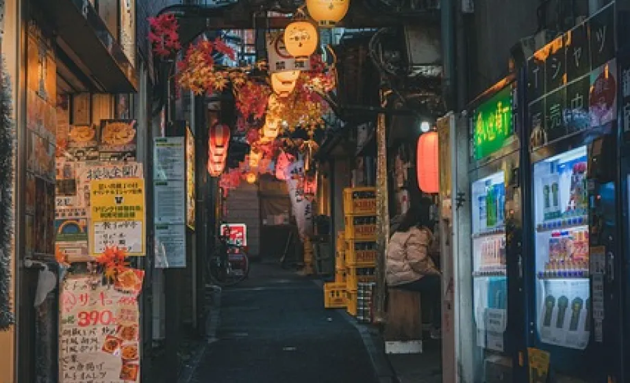 Lampions und japanische Zeichen in beleuchtender Gasse in der Nacht